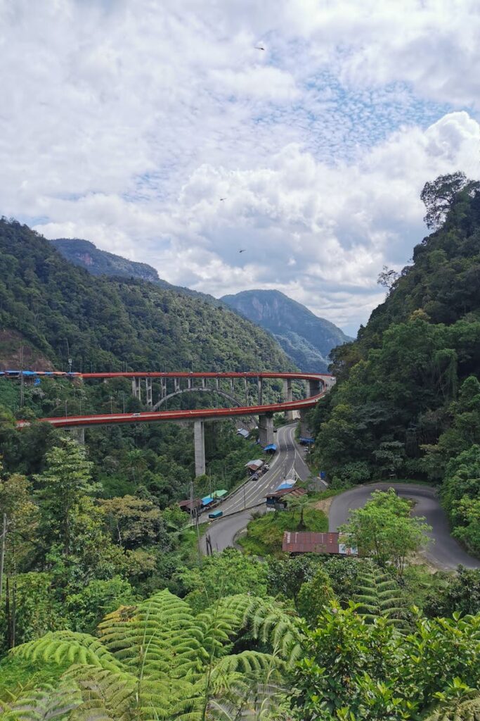 A stunning aerial view of the Harau Valley bridge surrounded by lush green forests in West Sumatra.